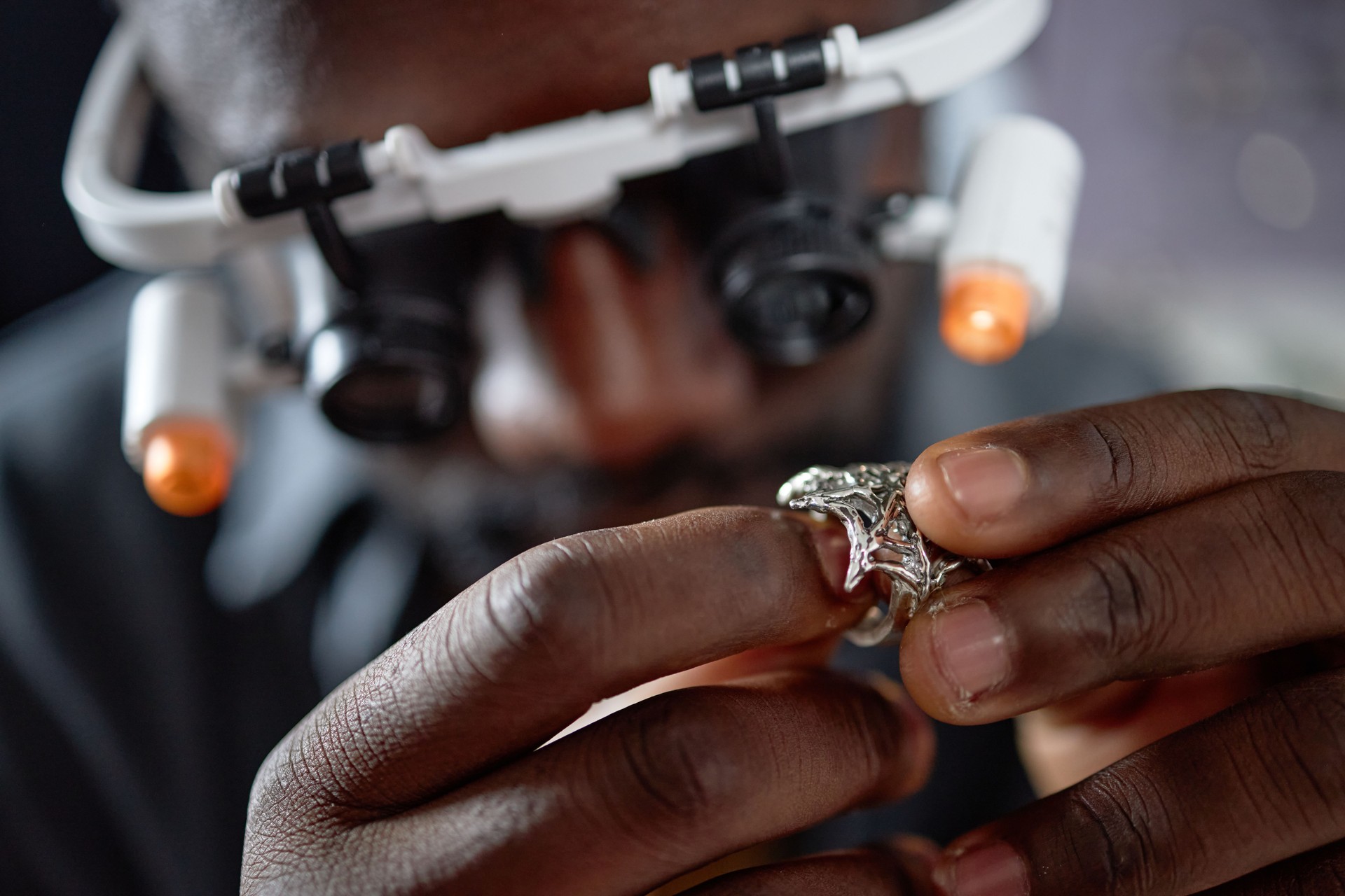 Examining Jewelry Using Magnifying Glass and Headset